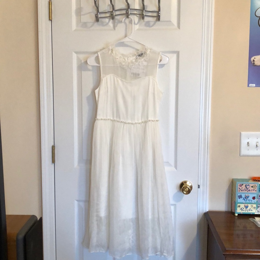 White dress, sleeveless, pearls at the waist